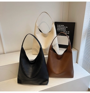 Detailed view of woven leather hobo bags in black, beige, and brown on display