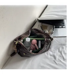 Top view of spacious dark brown leather bag interior with tablet and umbrella storage