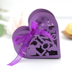 Detail of purple heart-shaped gift box with laser-cut LOVE text and violet organza ribbon