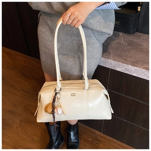 Detail view of cream vintage Boston bag with baseball charms and metallic logo