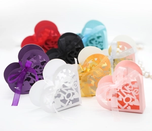 Macro shot of tiered heart-shaped LOVE laser-cut gift boxes with elegant ribbon bows