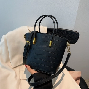 Close-up of black crocodile pattern handbag with elegant gold metal hardware details