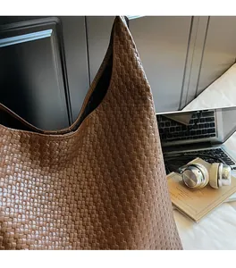 Detailed close-up of brown woven tote bag showing fine leather texture and soft craftsmanship
