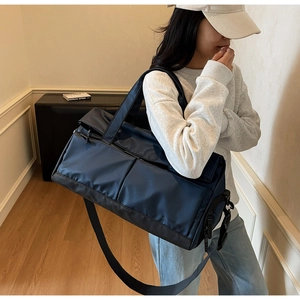 Sac de sport bleu marine en nylon avec compartiment sec-humide porté par un mannequin