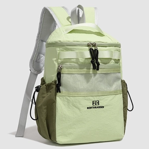 Detail of green two-tone nylon backpack with mesh zip pocket and tactical straps