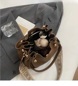 Intérieur du sac seau en cuir marron montrant le rangement pour parapluie et rouge à lèvres