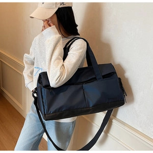 Détail du grand sac de sport bleu marine en nylon imperméable avec bandoulière amovible