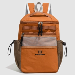 Detail of orange and brown nylon backpack with mesh pocket and drawstring side pockets
