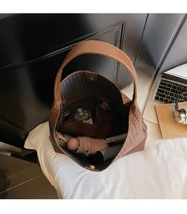 Spacious interior of brown woven tote bag showing large capacity and inner pouch