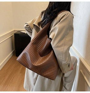 Close-up of a deep brown woven leather tote bag featuring handcrafted texture and soft shape