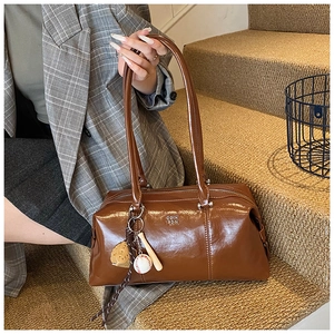 Detail of vintage brown leather Boston bag with baseball charms and brand logo