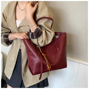 Dettaglio della borsa tote vintage bordeaux con nappa di perline e texture in pelle