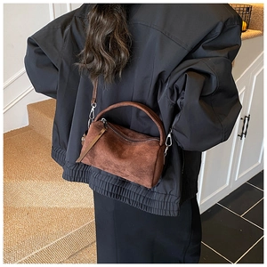 Braune matte Wildleder-Kissentasche, getragen von einem Modell in minimalistischem Stil