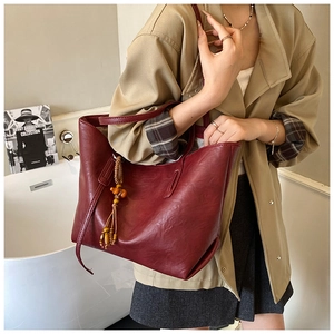Dettaglio della borsa tote bordeaux in pelle PU con nappa in legno e ampia capienza