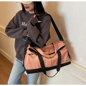 Vue détaillée du sac de sport rose avec bandoulière réglable et poche latérale