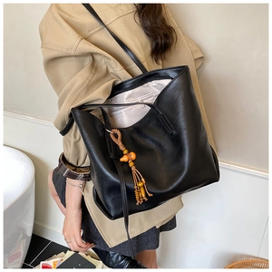Dettaglio della borsa tote minimalista in pelle PU nera con nappa decorativa in perline