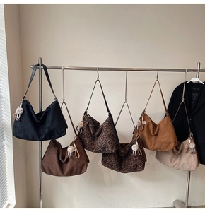 Vue détaillée de grands sacs hobo en diverses couleurs avec d'adorables pendentifs monstres