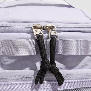Close-up of durable double zippers with black braided cords on a purple nylon backpack