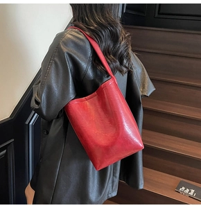Detail of red PU leather tote bag showing smooth matte texture and minimalist handle design