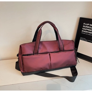 Détail du sac de sport bordeaux montrant le tissu imperméable et les coutures solides