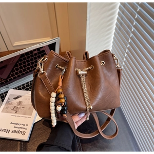 Brown PU bucket bag detail with golden chain drawstring and decorative beads