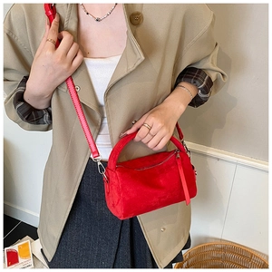 Makrodetail der roten Veloursleder-Bostontasche mit verstellbarem Gurt und Reißverschluss