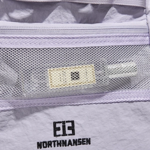 Detail of Northnansen purple nylon backpack showing mesh pocket and logo embroidery