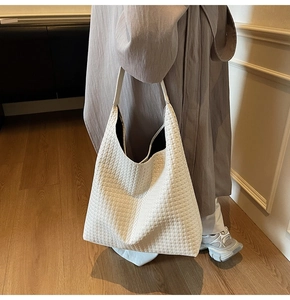 Macro detail of white woven leather tote bag showing high-quality braided texture