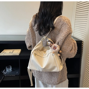 Minimalist creamy white oversized tote bag on model highlighting its soft drape and texture