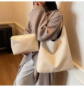 Detailed view of white woven tote bag set with matching zipper pouch on a model