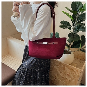 Detail of burgundy suede tote bag featuring silver buckle and slim double shoulder straps