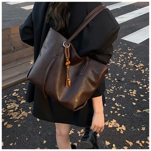 Borsa tote vintage marrone scuro con nappa indossata dalla modella in un ambiente autunnale