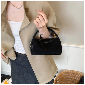 Matte schwarze Pillow-Bag kombiniert mit Khaki-Trenchcoat für urbanen Minimalismus