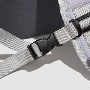 Detail of light purple nylon backpack with durable black plastic buckle and silver webbing