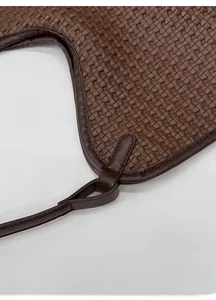 Detail of reinforced woven handle and precision stitching on dark brown tote bag