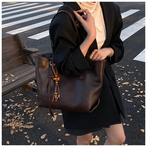 Borsa tote marrone in pelle con texture vintage ed elegante dettaglio nappa a frange