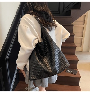 Close-up of black woven leather tote bag with Intrecciato pattern and large capacity