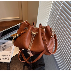 Brown leather bucket bag with metal drawstring chain and tricolor wooden bead pendant