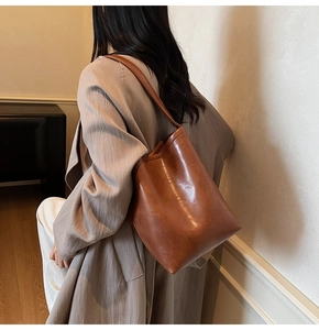 Vue détaillée du grand sac cabas marron montrant la texture du cuir ciré et la bandoulière