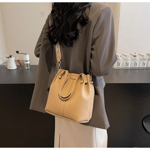 Détail du sac seau camel avec texture litchi et large bandoulière brodée ethnique