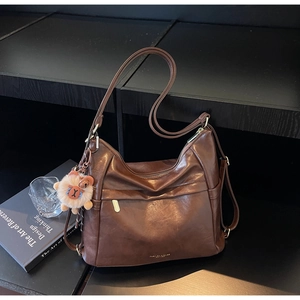 Detail of brown faux leather tote bag with vintage texture and gold zipper accent