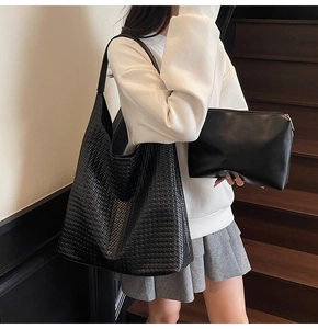 Detail of woven leather hobo bag and matching pouch showing intricate texture on the strap
