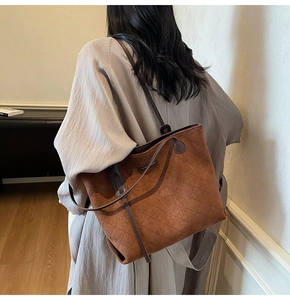 Brown quilted suede tote bag with diamond stitching shown on a model for shoulder carry
