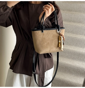 Detail of leopard print bucket bag with vintage beaded charm and black leather handles