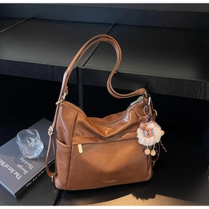 Detail of vintage brown shoulder bag with zipper pocket and cute sheep plush charm