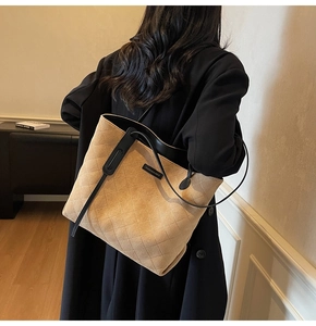 Brown quilted suede tote bag worn over the shoulder showing large capacity and soft texture