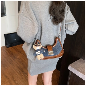 Model view of the navy denim moon bag with brown leather trim and teddy bear charm