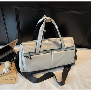 Détail macro du sac de sport argenté avec texture en nylon et accessoires de voyage