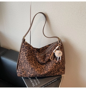 Détail du sac cabas léopard en daim avec fermeture éclair et pendentif en peluche