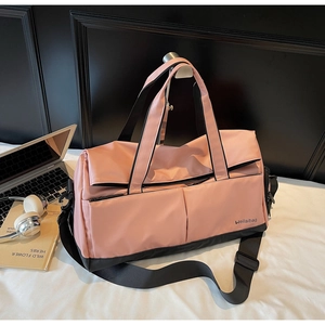 Vue détaillée du sac de sport en nylon rose et noir avec bandoulière réglable et logo